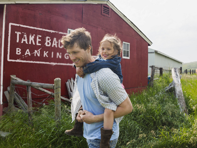 Image of a man with a Kasasa Saver Savings Account carrying his daughter